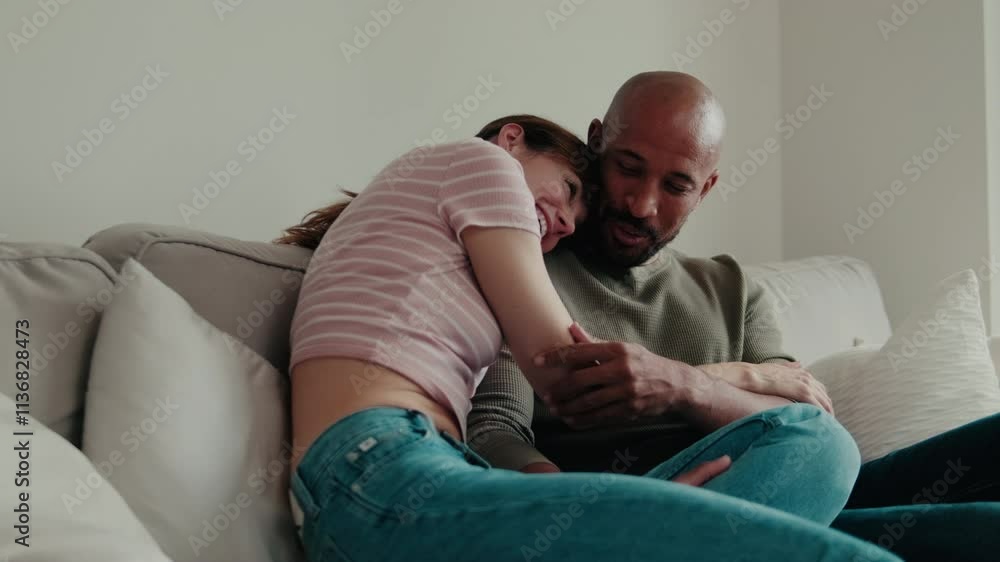 Happy couple relaxing together at home on the couch. Love, relationship, happiness, interracial couple, home, comfort, relax Happy couple relaxing together at home on the couch. Love, relationship, happiness, interracial couple, home, comfort, relax