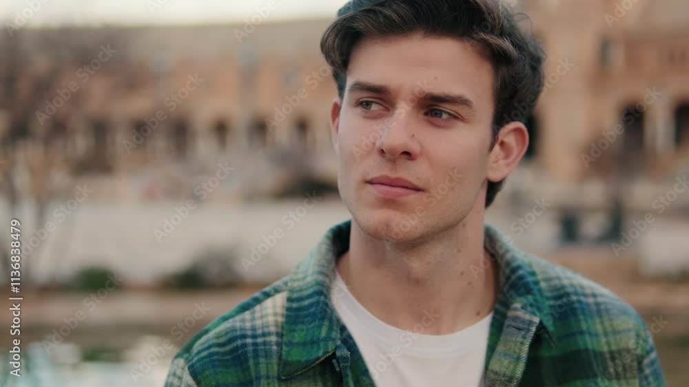 Close-up of young man looking around at an old city background