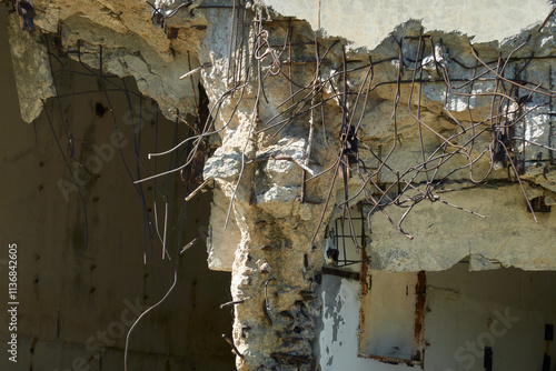 Dismantling of reinforced concrete structure. Hole in the wall with bare reinforcement sticking out in different directions. Copy space. photo