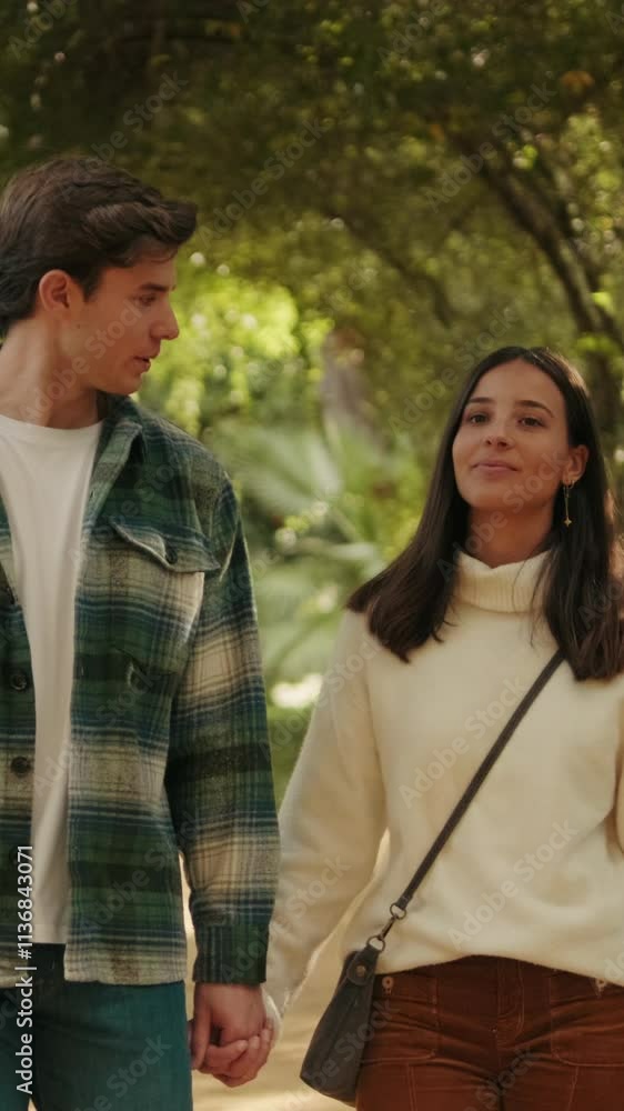 Vertical video, Happy young couple man and woman walking inside green arch Vertical video, Happy young couple man and woman walking inside green arch