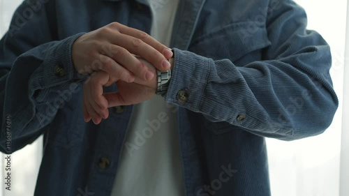 A man in a blue shirt checks the time on his wristwatch.
A man looks at the time on his watch.
Time on wristwatch.
A business man has a watch on his hand.
Man is in a hurry and looks at his watch photo