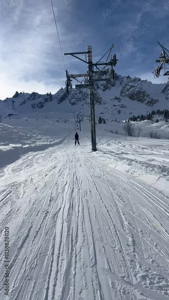 Drag lift with skiers going up on the mountain Drag lift with skiers going up on the mountain