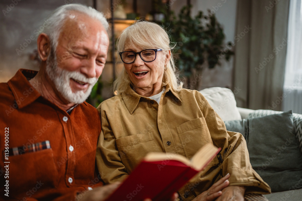 senior couple husband and wife sit on sofa and read a book together senior couple husband and wife sit on sofa and read a book together