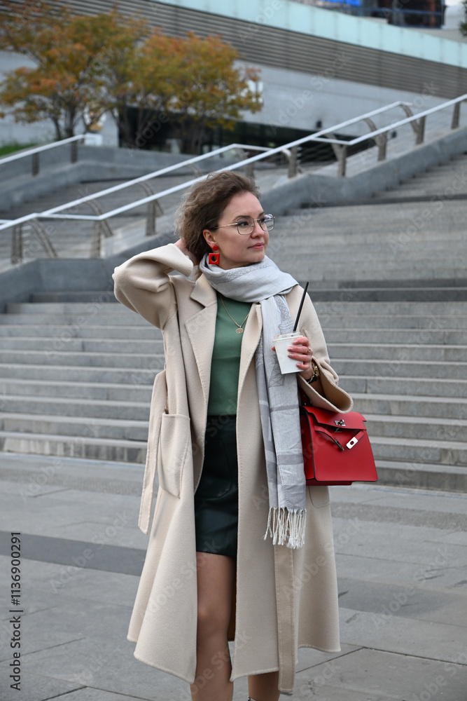 Fototapeta premium A young woman of European appearance outdoors with a red bag