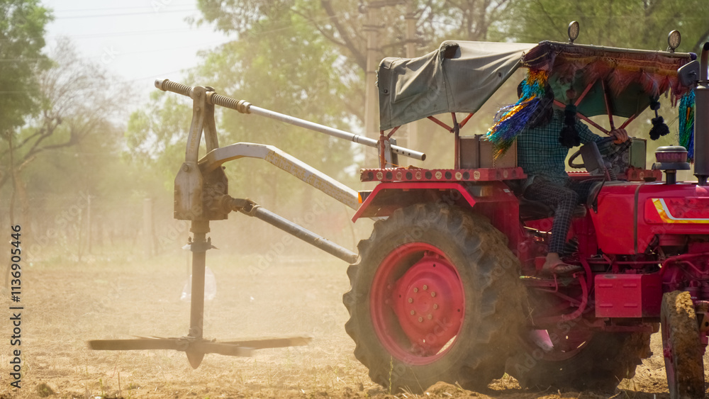 Obraz premium Tractor spreading organic fertilizer on farmland with dust flow in action. Farmers preparing the soil for crop seeding. A spinning machine to mixing the manure in motion. Modern agricultural concept