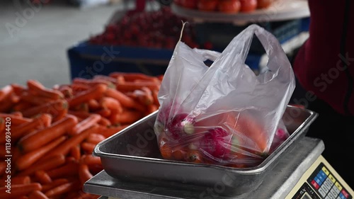 A vendor weighs vegetables at the local produce market.