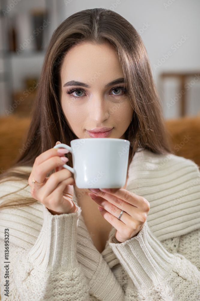 A woman is enjoying a warm cup of tea in a cozy and inviting setting filled with comfort and warmth A woman is enjoying a warm cup of tea in a cozy and inviting setting filled with comfort and warmth