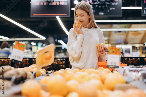 Woman smelling orange at grocery store fruit stand