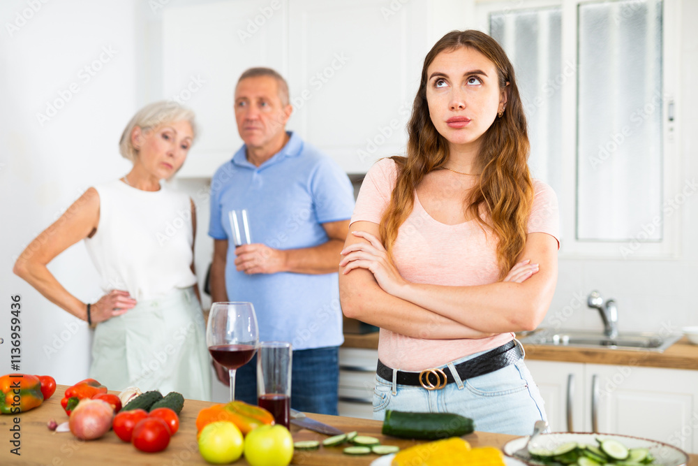 Offended young woman standing back to her parents, not speaking at home Offended young woman standing back to her parents, not speaking at home
