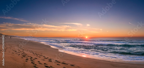 Monterey Bay Sunset with lonely beachcomber footprints.  Beach stretches forever