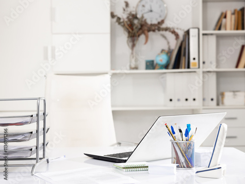 Fotografie Workplace in office with white notebook, chancellery, phone and metal paper shel