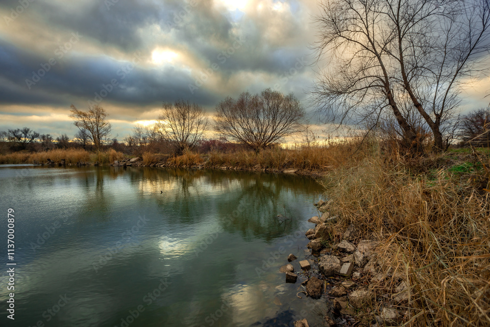 Beautiful landscape with lake and big and smooth clouds in the sky , autumn season, water and trees . Reflections on the water , stormy clouds in the sky . Photography in the forest iwith lake . Beautiful landscape with lake and big and smooth clouds in the sky , autumn season, water and trees . Reflections on the water , stormy clouds in the sky . Photography in the forest iwith lake .