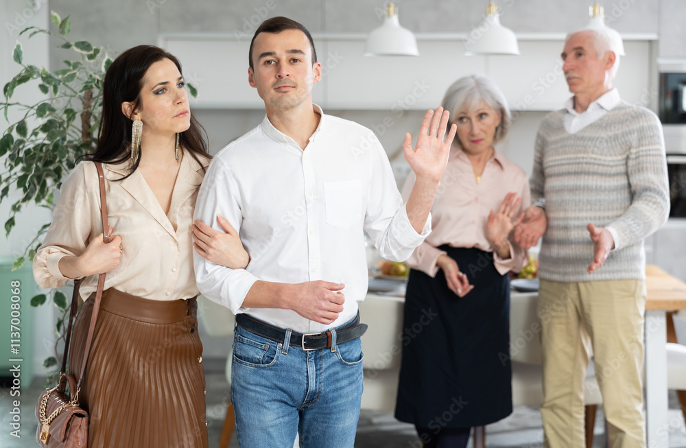 Grumpy elderly parents condemn and look unkindly after newlyweds. Family conflict, pensioners send their son with girlfriend out of apartment. Dispute discord within family, condemnation and rejection Grumpy elderly parents condemn and look unkindly after newlyweds. Family conflict, pensioners send their son with girlfriend out of apartment. Dispute discord within family, condemnation and rejection