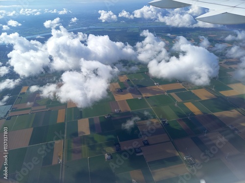Adorable aerial view of expansive farmland with clouds from airplane