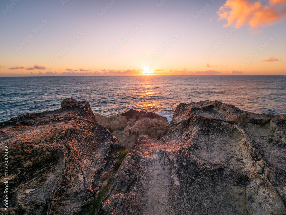 Obraz premium Sunrise Over the Ocean with Rocks