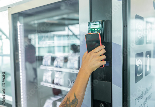 Traveler using mobile phone for easy payment at airport kiosk photo