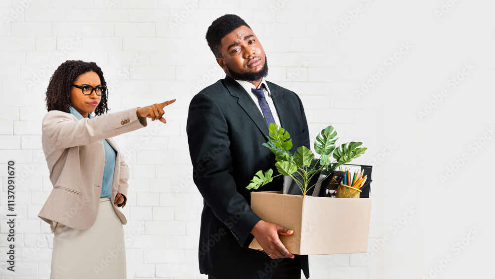 Young black businessman with cardboard box being fired by his frustrated female boss at office