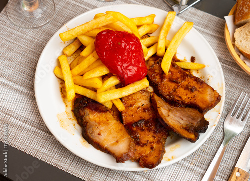 Delicious pork with boiled potatoes and stewed peppers on a plate photo