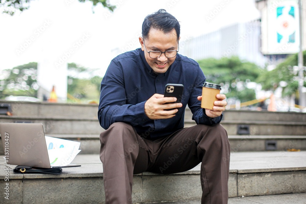 Portrait Of Smiling Employee Man Using Smartphone While Holding Coffee Cup Portrait Of Smiling Employee Man Using Smartphone While Holding Coffee Cup