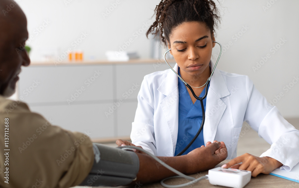 Φωτογραφία Young Focused African American Lady Examining Older Patient Measuring Arterial Blood Pressure With Stethoscope And Sphygmomanometer Medical Device Sitting At Table