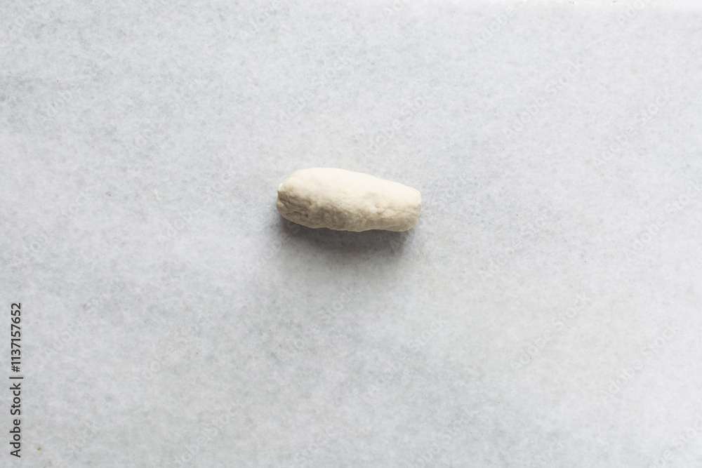 Obraz premium Overhead view of noodles dough on a marble countertop, top view of homemade biang biang noodles dough, process of making hand pulled noodles