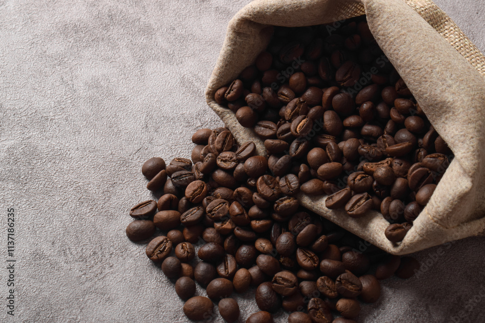 Coffee beans in bag isolated on dark cement background Coffee beans in bag isolated on dark cement background
