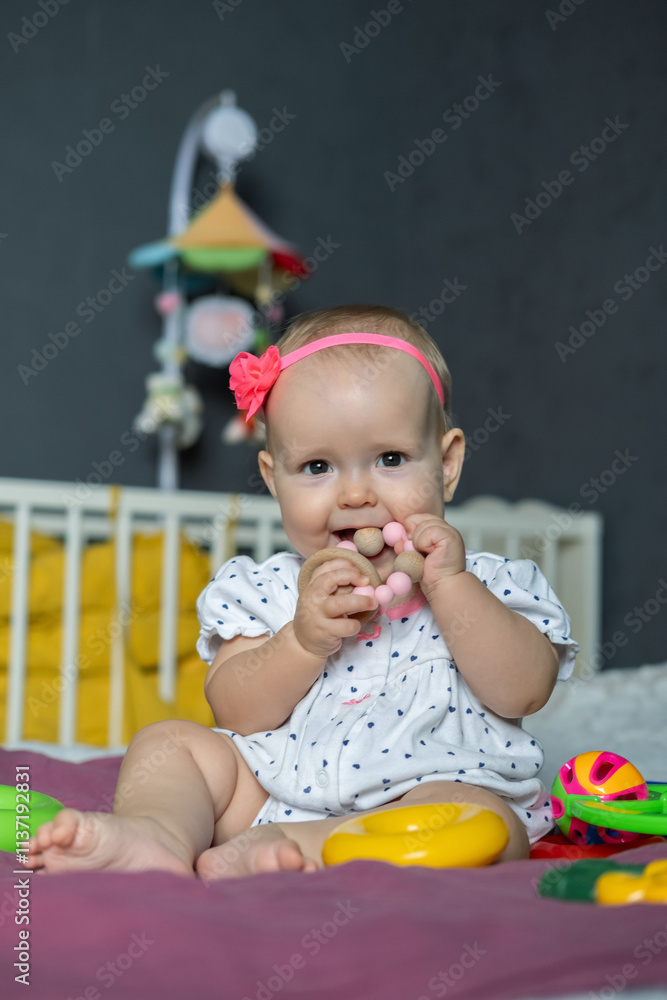 A cheerful baby girl sits on a soft surface, surrounded by colorful toys. She is playfully grasping a teething ring with delight in her eyes, radiating happiness in her playful world. A cheerful baby girl sits on a soft surface, surrounded by colorful toys. She is playfully grasping a teething ring with delight in her eyes, radiating happiness in her playful world.