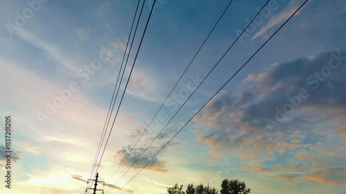 Beautiful sunset sky with clouds and power lines at dusk