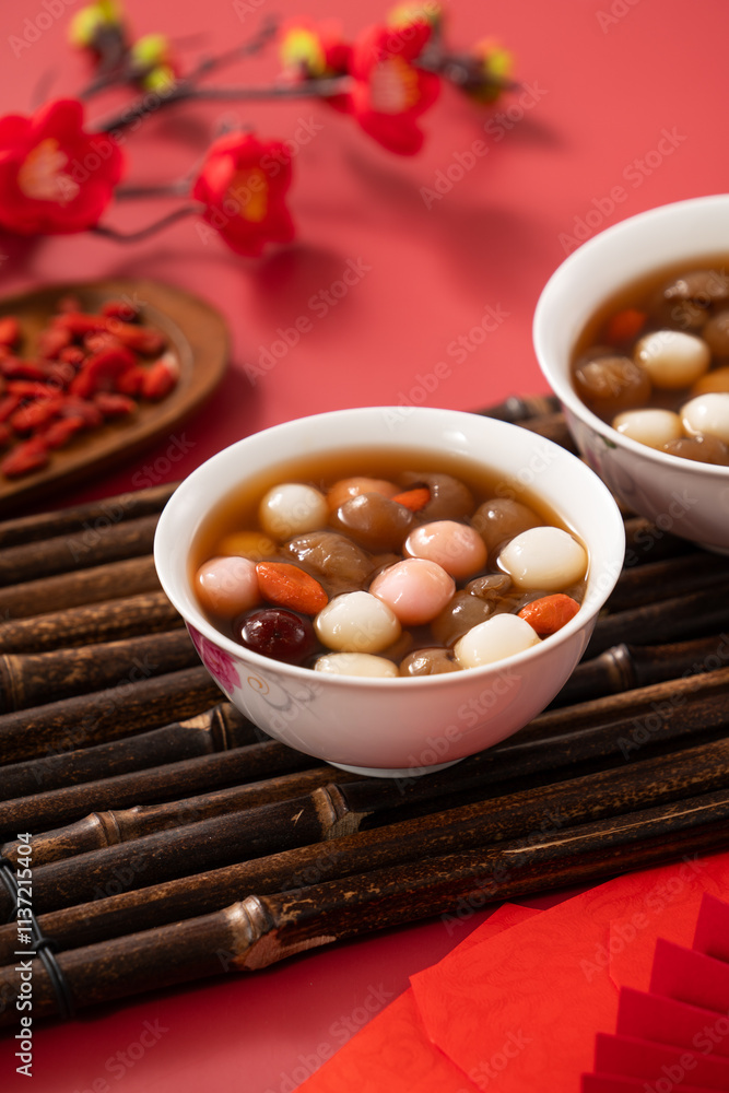 Red and white tangyuan with syrup soup, dried longan pulp, red dates for Chinese lunar new year.