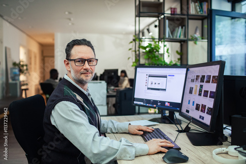 Professional man working at dual monitors in modern office setup