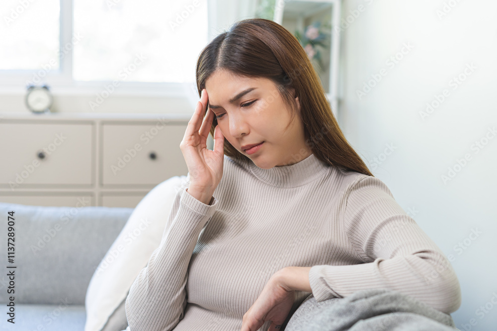 Depressed anxiety asian young woman frustrated hand on head, touching her temples, suffering stressed, sick, tired, crisis on sofa from headache, migraine pain tension problem health care concept. Depressed anxiety asian young woman frustrated hand on head, touching her temples, suffering stressed, sick, tired, crisis on sofa from headache, migraine pain tension problem health care concept.