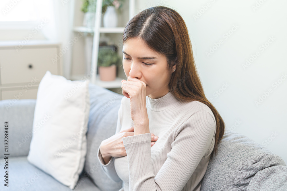 Unhealthy sickness asian young woman, girl unwell with coughing, have cold, sore throat on sofa, couch at home, suffering with symptom cough feeling bad. Health care of Coronavirus, covid-19 concept. Unhealthy sickness asian young woman, girl unwell with coughing, have cold, sore throat on sofa, couch at home, suffering with symptom cough feeling bad. Health care of Coronavirus, covid-19 concept.