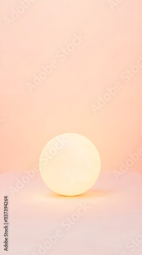 Illuminated Sphere on Pale Pink Surface Background