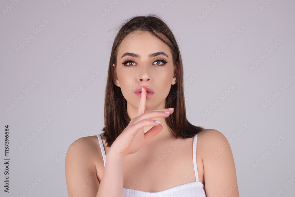 Secret young woman isolated on studio background. Say hush be quiet with finger on lips, shhh gesture. Sign of silence gesture saying shh or keeping a secret. Woman asking to keep silence. Secret young woman isolated on studio background. Say hush be quiet with finger on lips, shhh gesture. Sign of silence gesture saying shh or keeping a secret. Woman asking to keep silence.
