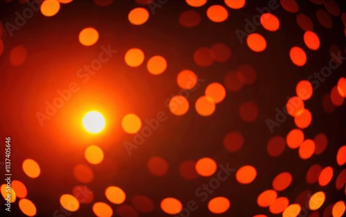 A blurred image of glowing orange and yellow circular lights against a dark background.