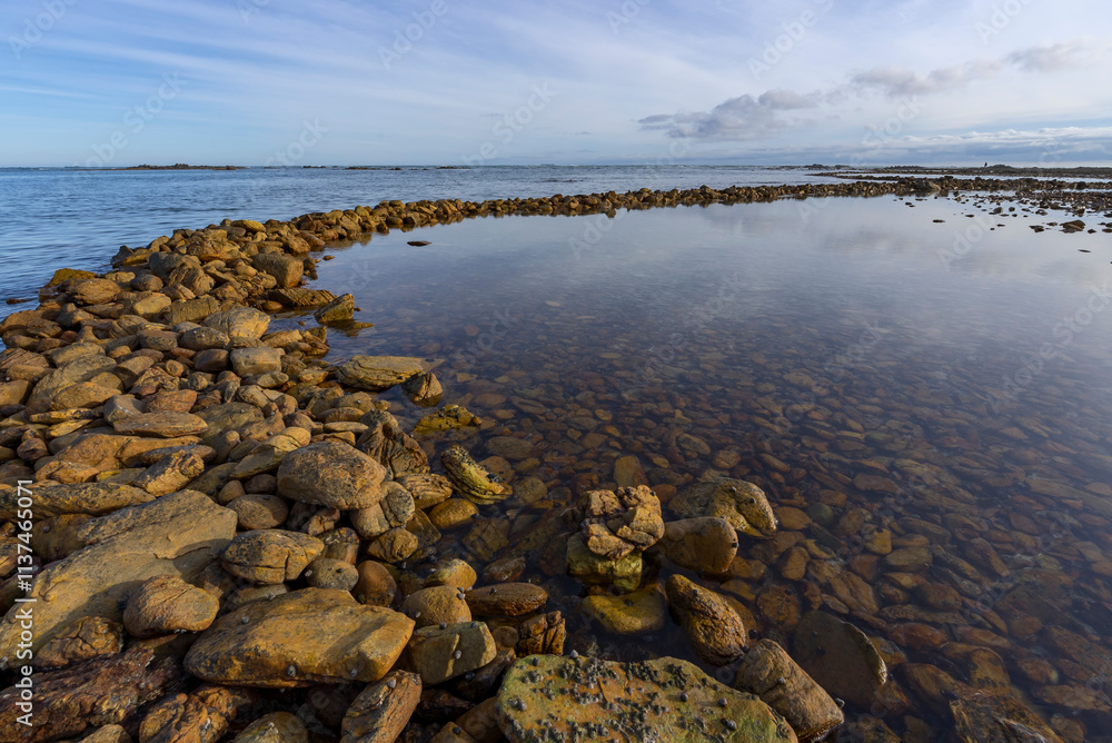 Ancient Rasperpunt fish traps along the L'Agulhas shoreline in the Agulhas National Park. These tidal fish traps were probably built by pre-colonial Late Stone Age people. Western Cape. South Africa. Ancient Rasperpunt fish traps along the L'Agulhas shoreline in the Agulhas National Park. These tidal fish traps were probably built by pre-colonial Late Stone Age people. Western Cape. South Africa.