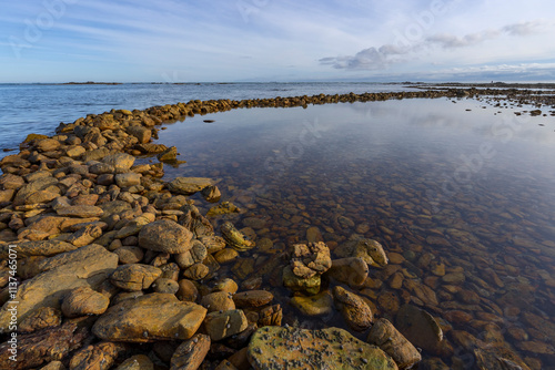 Ancient Rasperpunt fish traps along the L'Agulhas shoreline in the  Agulhas National Park. These tidal fish traps were probably built by pre-colonial Late Stone Age people. Western Cape. South Africa.