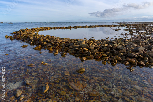 Ancient Rasperpunt fish traps along the L'Agulhas shoreline in the  Agulhas National Park. These tidal fish traps were probably built by pre-colonial Late Stone Age people. Western Cape. South Africa.