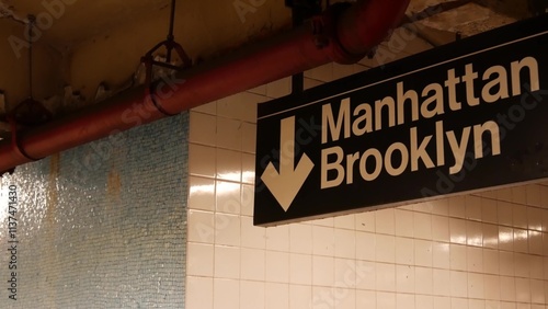 New York subway station interior, Manhattan text sign. Underground metropolitan. United States metro transport navigation. Information signage public passenger railway. Downtown and Brooklyn direction
