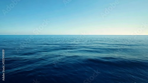 A video featuring a vast body of water with a clear blue sky stretching across the horizon, An endless blue ocean under a clear day sky