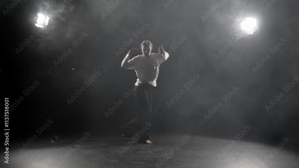 Energy of movement, woman dancing in dark studio, slow motion shot in darkness. Joyful female dancer dancing actively in dance hall, hip-hop dance style and contemporary choreography, hobby in pastime Energy of movement, woman dancing in dark studio, slow motion shot in darkness. Joyful female dancer dancing actively in dance hall, hip-hop dance style and contemporary choreography, hobby in pastime