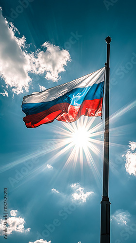 A Russian Federation flag flies high on a flagpole against a blue sky and bright sun. photo