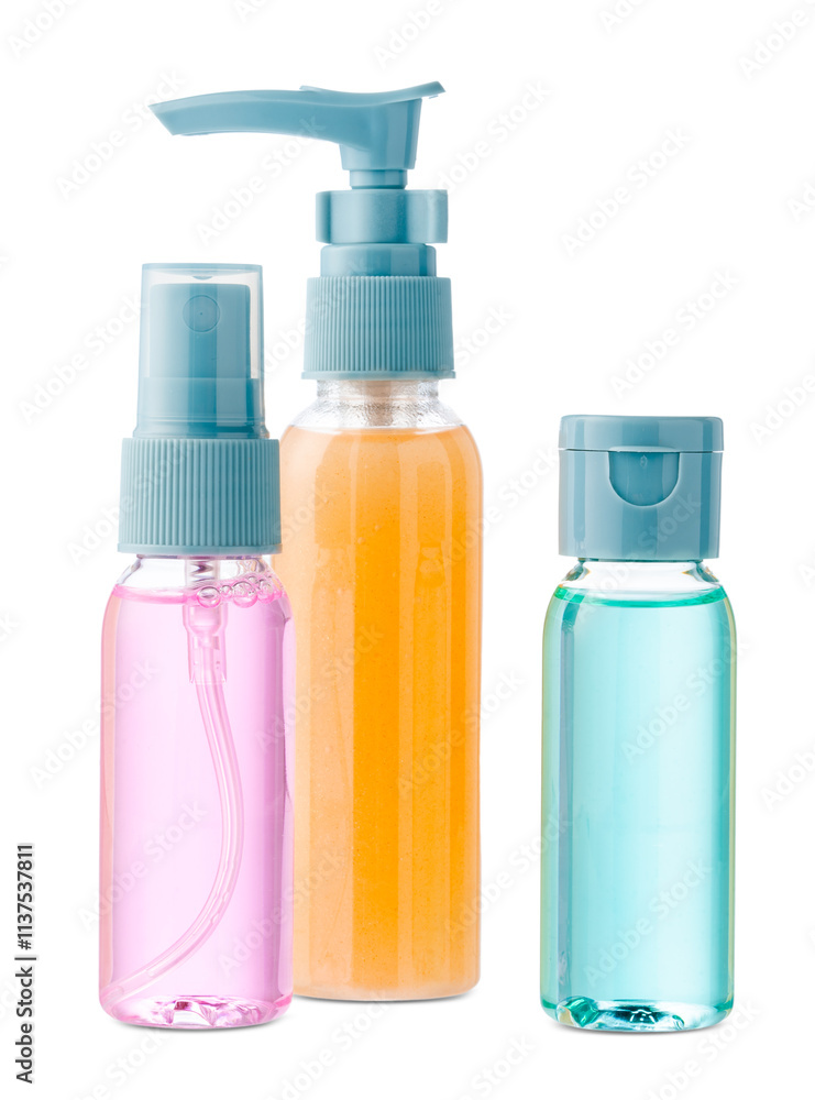 Various bottles with colored liquids and pumps arranged on white background
