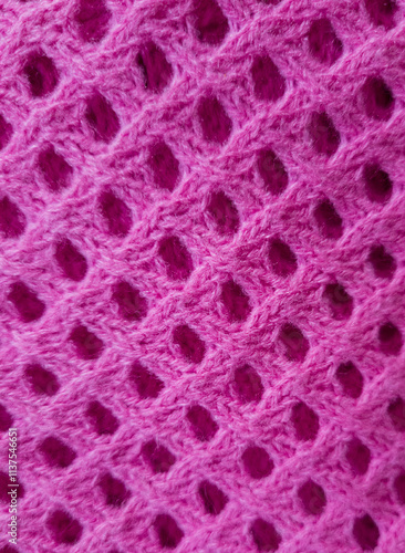 pink knitted wool fabric photographed close-up in a special design. Texture stands out with material. Clothing background sweater