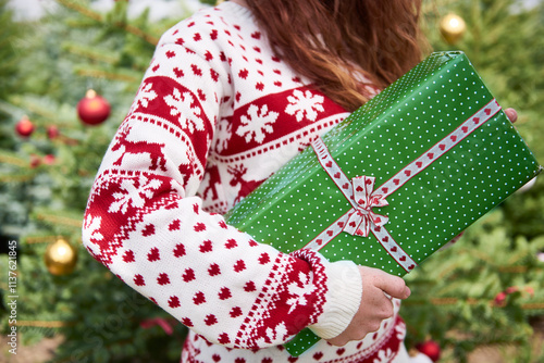 Woman holding Christmas present, partial view photo