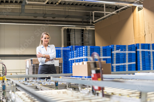 Woman looking at conveyor belt in factory photo