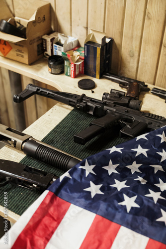 Rifles, guns and American flag on table