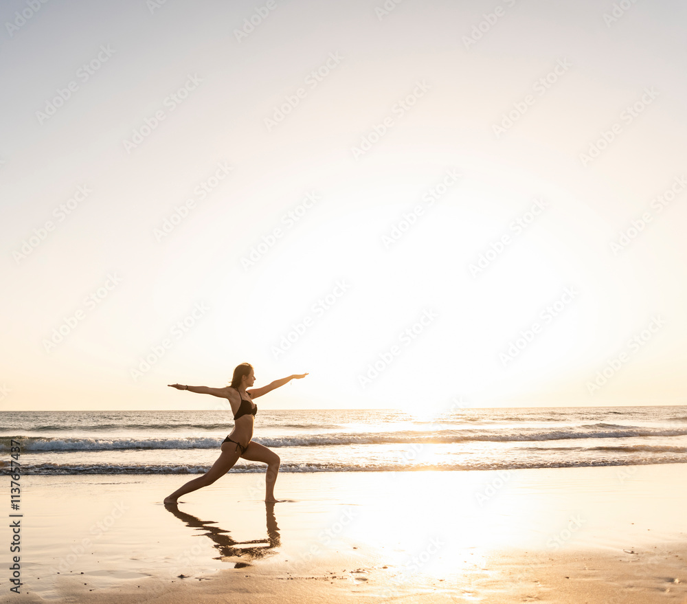 Young woman practicing yoga on the beach, sitting on surfboard, meditating Young woman practicing yoga on the beach, sitting on surfboard, meditating