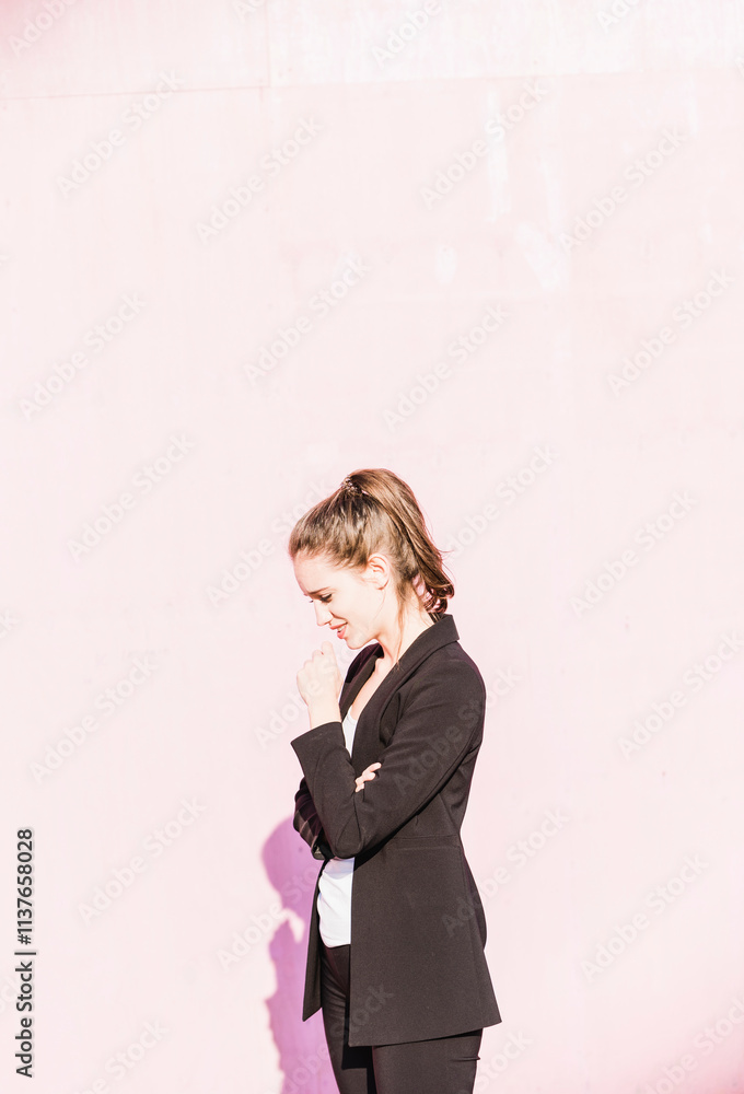 Smiling young woman standing in front of pink wall Smiling young woman standing in front of pink wall