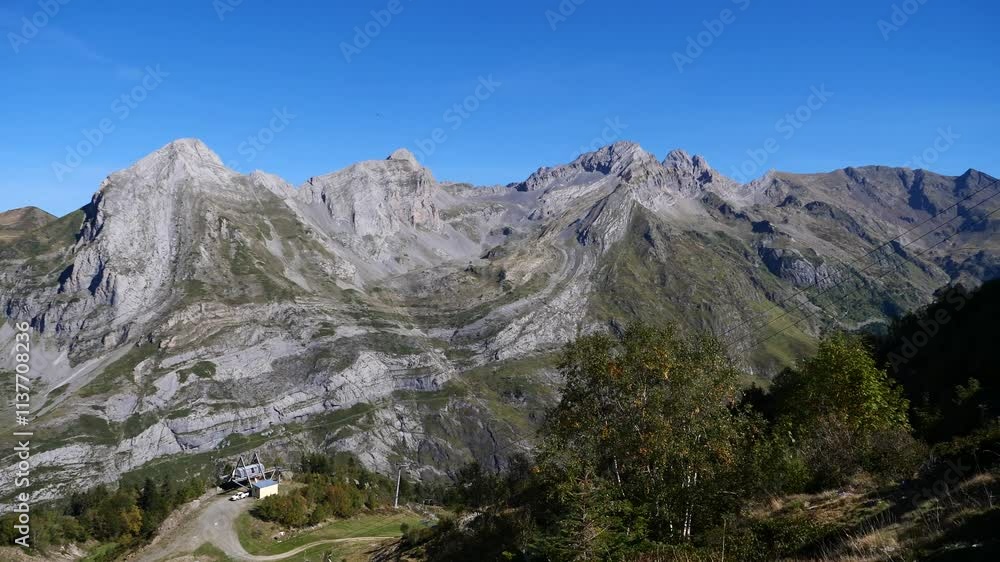 Mountain range with a small village in the foreground. The sky is clear and the sun is shining brightly Mountain range with a small village in the foreground. The sky is clear and the sun is shining brightly